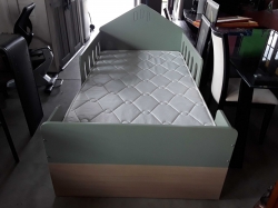 Children's bed with mattress and wall shelf