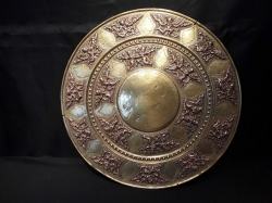 A large very old brass charger wall hanging highly embossed Arabian dancing figures in copper