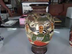 An antique Japanese 30cm satsuma baluster vase depicting faces of people stamped to base