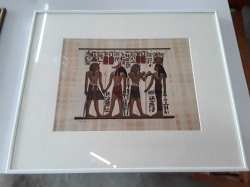 A vintage Egyptian painting on authentic papyrus paper in a white metal frame