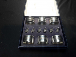 A boxed vintage set of 6 silver plate napkin rings & 6 cast swans for table places
