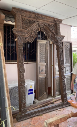 Teak door arch with wide frame carved in Thai style.