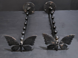 A pair of decorative black colored metal butterfly cloth hanging rails.
