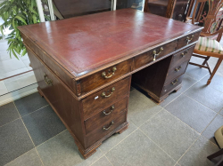 A Georgian Mahogany partners desk with red leather top and 9 drawers each side on ogee bracket feet with original steel casters. Both Pedestals have unusual old brass handles so the desk can be moved around without dismantling. D.97 W.137 H.77 Cm.