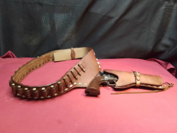 A reproduction COLT western revolver in heavy leather holster and bullet belt (non firing)