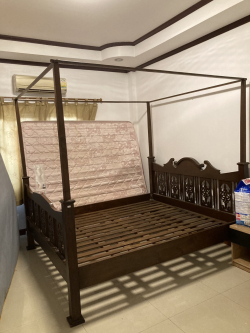 A 4 poster Wooden king size bed with mattress.