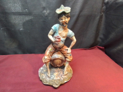 A Large Capodimonte Figurine of Town Drunk Sitting on Barrel. H.42 W.20 Cm.