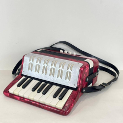 A vtg. Red Accordion with 17 keys in good condition. w. 23 H.24 D. 11 Cm.