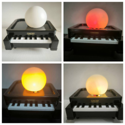A decorative desk lamp in shape of piano with sensor light (three color lights)