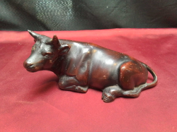 A heavy bronze sitting bull. W.20 H.9 Cm.  