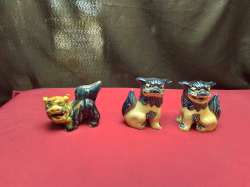 A pair of sat blue and white Japanese foo dogs And one crouching blue foo dog 