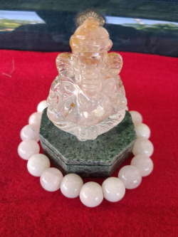 A natural clear Quartz hand carved Lord Ganesh with a dark green stone base and a beautiful white Jade bracelet.