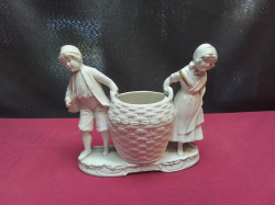 An 1890-1930 bisque porcelain figurine of a boy and girl with large basket (marked underneath Germany 2265) 15cm high x 16cm long
