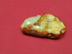 A heavily carved green jade piece 5cm long 
