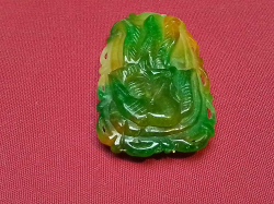 A heavily carved green jade piece 4.5cm long 