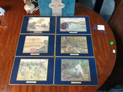 A set of 6 unused plates mats with different top artists.20x28 Cm.