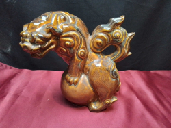 A Chinese foo dog stood on a ball. W.18 H.18 Cm.  