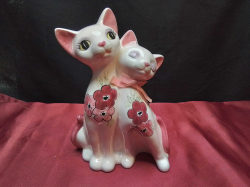 A ceramic money box in the shape of two cats. W.14 H.19 Cm.