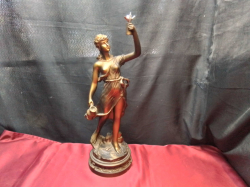 A Resin statute of a lady raising a silver bird. W.16 H.50 Cm. 