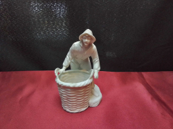 An 1890-1930 German bisque porcelain figurine of a boy with large basket. 14cm high