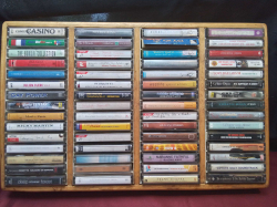 60 Tape Cassettes, in a wooden wall hanging case.32x50 Cm.