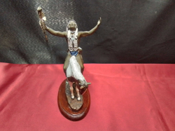 A hand painted pewter figure on wooden stand of a native American warrior on horseback. 13cm wide x 20cm high. 