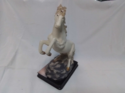 A Lovely Bisque Figure of a Prancing Stallion. W.11 D.17 H.26 Cm. (Horn A/F)