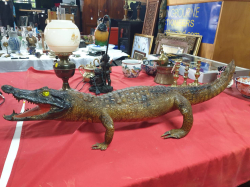 A crocodile standing on four legs with mouth open and tail up with glass eyes. W.31 L.106 H.24Cm.