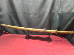 A golden hand painted samurai sword on a stand.W.95 Cm. 