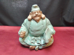 A vintage porcelain Oriental Japanese man carrying fish. W.19 H.22 Cm.
