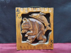 A wooden hand carved wall plaque showing a bear and a fish 21cm x 18cm