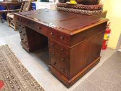 An early Victorian English C,1840 mahogany twin pedestal desk 
Freestanding finish on the back with the original turned  handles standing on the original wooden casters with key. D.77 W.150 H.75 Cm.