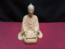 A Sitting Chinese statue of a student reading. W.12 H.14 Cm.