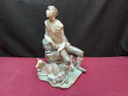 A LLADRO Figure of A Shepherd seated on a rock with a dog a ewe and a lamp. W.19 H.28 Cm.