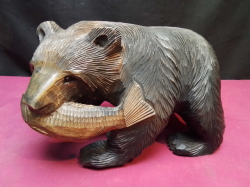 A large hand carved wooden bear with a fish. W.22 H.13 Cm.