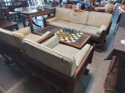 An antique hand carved  Thai three piece settee and hand carved coffee table with glass top (4 pieces)