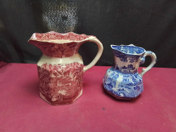 2 Masons Ironstone Jugs one in Red Vista Pattern W.17 H.16 Cm. , the other in Blue Willow W.13 H.13 Cm.