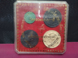 A set of four boxed Thai amulets