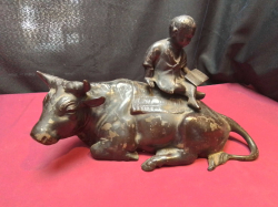 A cast iron vintage farmer riding a bull sculpture. L.32 H.20 Cm.
