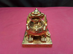 Chinese gold colored guardian dog sat on coins on its own base. W.8 D.9 H.8 Cm.