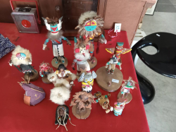 A collection features multiple handcrafted Native American-style kachina dolls.
