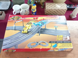 A Fast Lane Speedy Racer slot car set features a 7.5-foot track with a bridge and two formula-style racing cars.