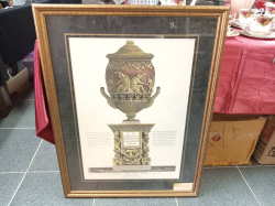 A framed art print depicts a classical Roman urn after the original etching by Giovanni Battista Piranesi. 67x87 Cm.