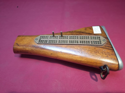 A vintage cribbage board made from a rifle stock and used bullets (with scoring pegs inside)