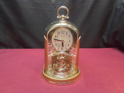 A Lovely Gold Colour Clock. W.18 D.12 H.29 Cm.