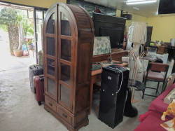 An arched wooden cabinet features glass doors and two bottom drawers. D.30 W.85 H.180 cm.