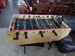 This Bonzini B60 football table features a classic wood finish and a coin-operated mechanism with small with table.