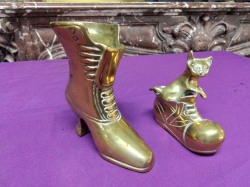 A Large Brass Boot and a smaller one with a cat inside.