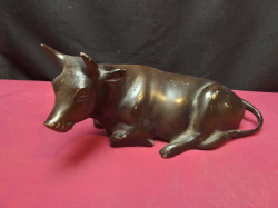 A bronze painted sitting bull. L.27 W.12 H.13 Cm.