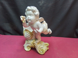 A vintage porcelain cherub figurine featuring gold-accented foliage and holding small pink flowers. W.20 D.21 H.30 Cm.